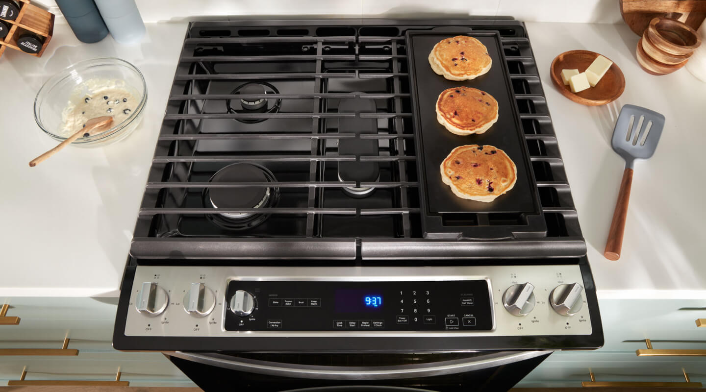 Overhead view of pancakes cooking on a stovetop griddle