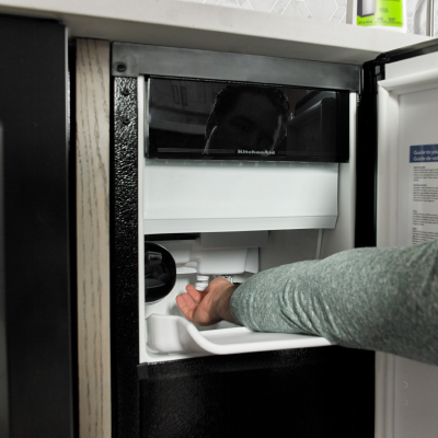 Person removing ice from an icemaker