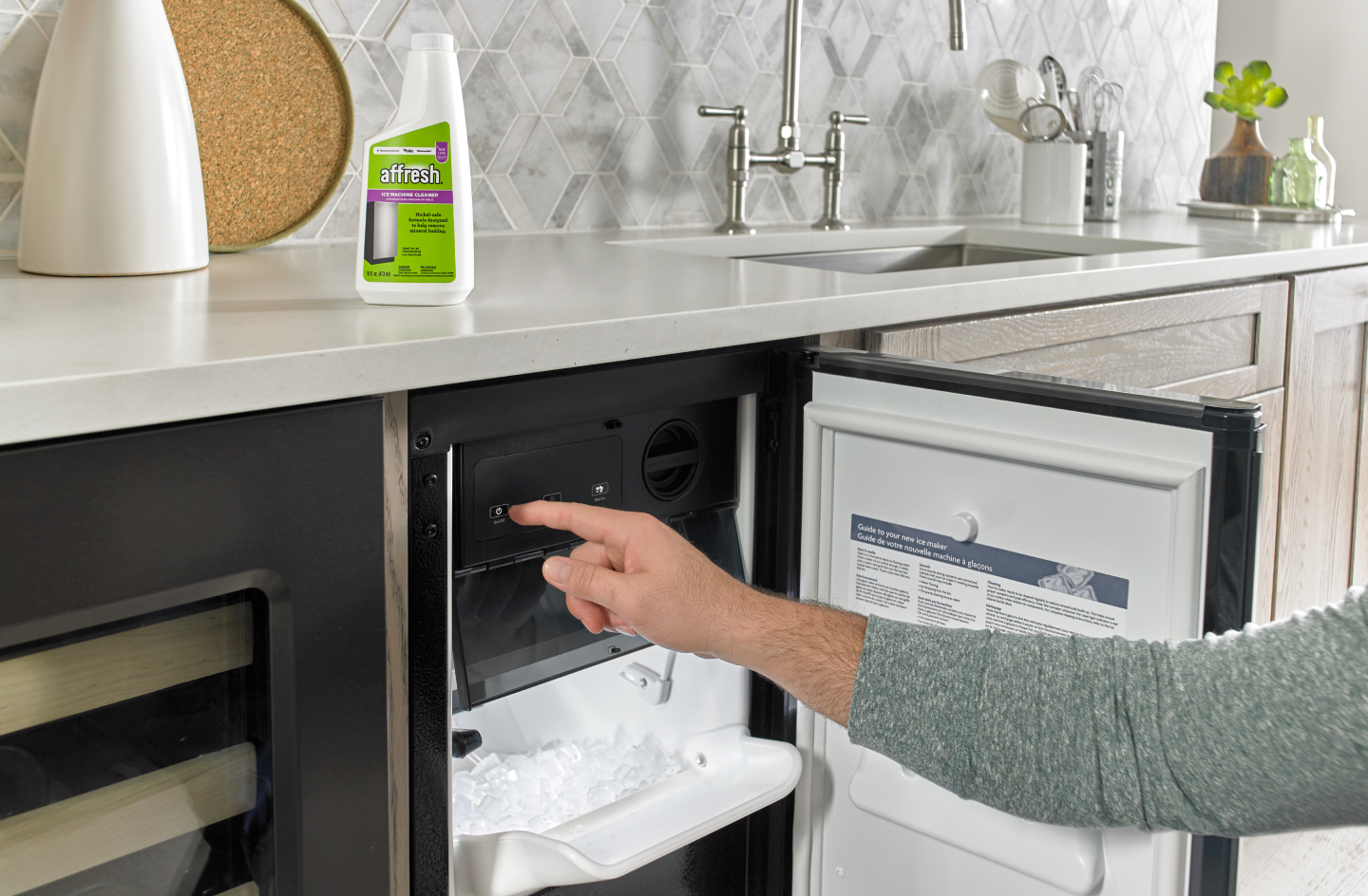 Person opening a built-in icemaker next to affresh® cleaner Person opening a built-in icemaker next to affresh® cleaner
