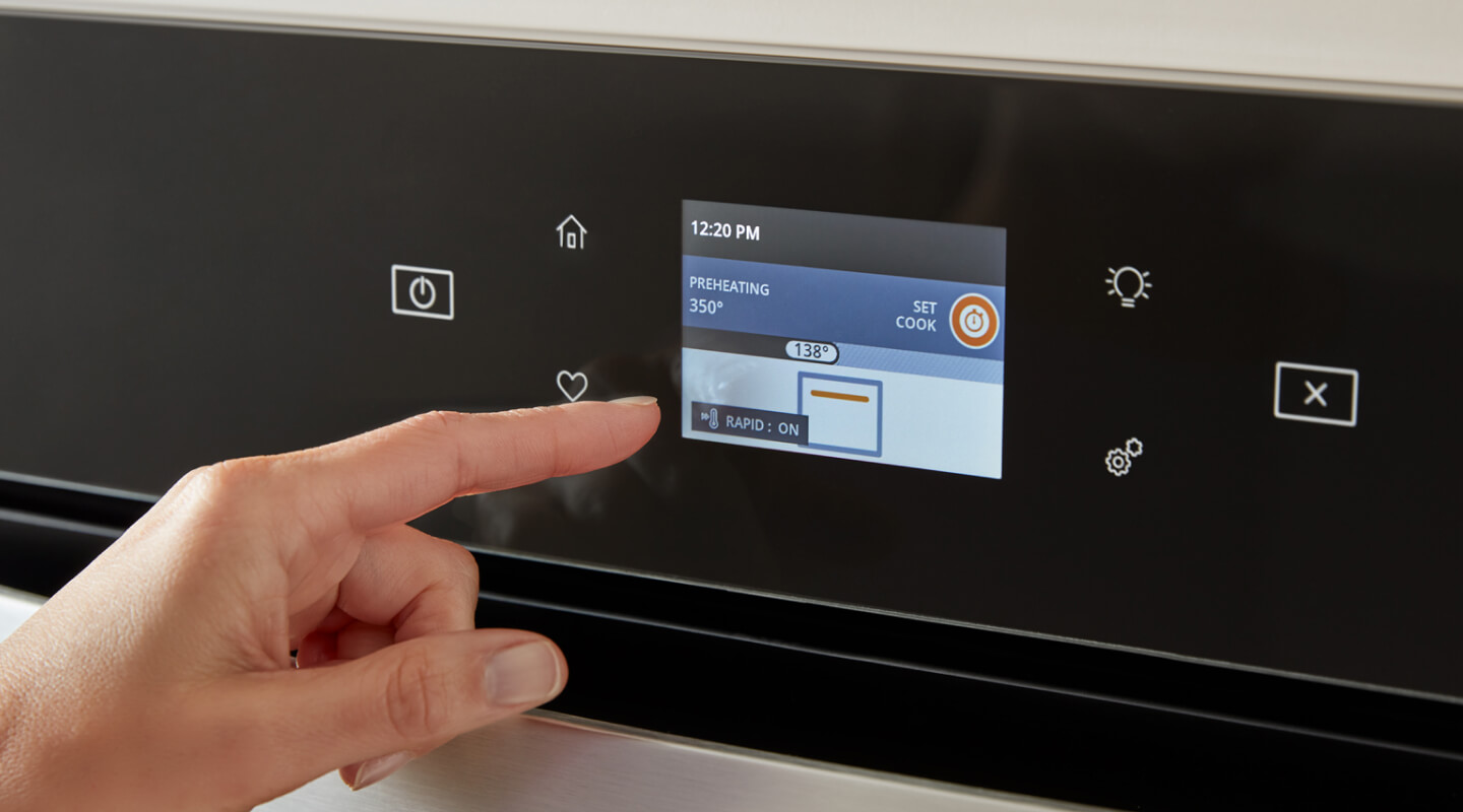 A person selecting a setting on an oven control panel A person selecting a setting on an oven control panel