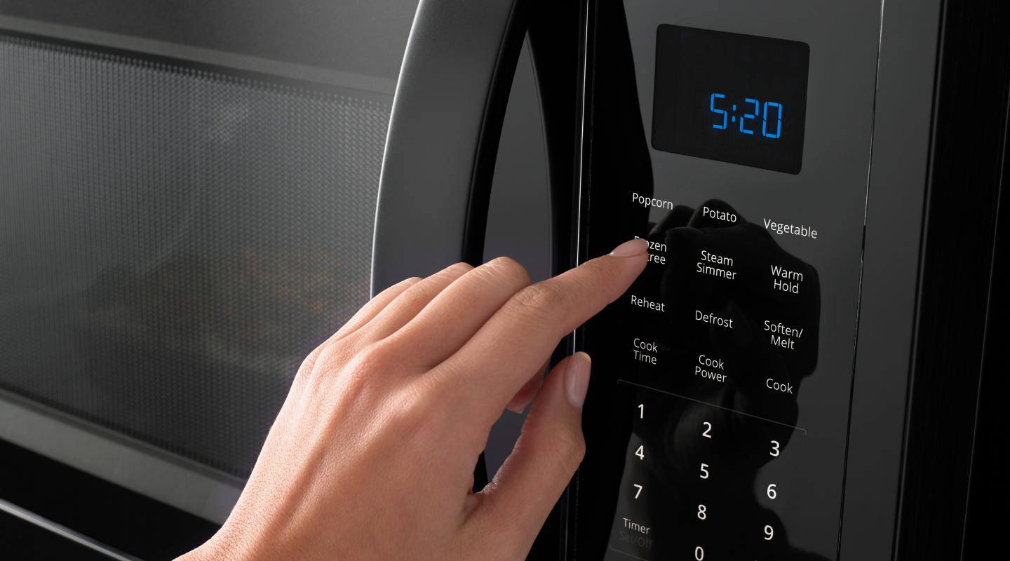 Hand pressing a microwave display Hand pressing a microwave display