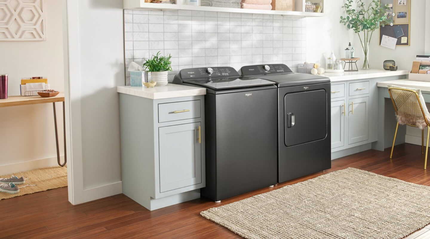 A black Whirlpool® Washer and Dryer set in a home