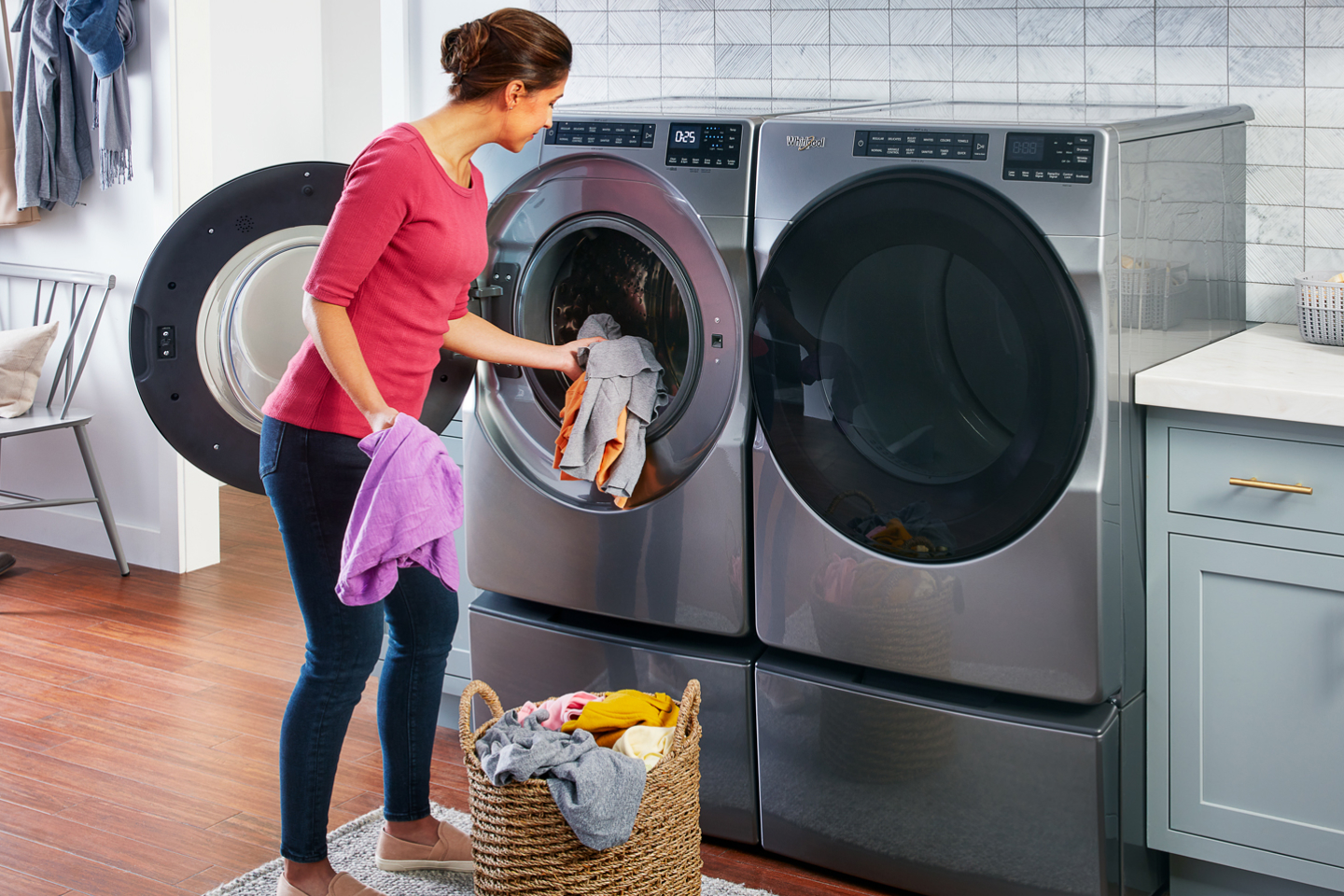 Person loading laundry into a slate gray Whirlpool® washing machine Person loading laundry into a slate gray Whirlpool® washing machine