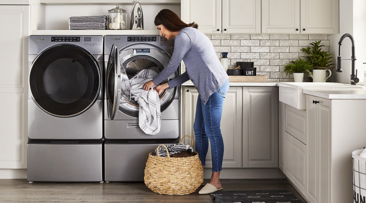 Person loading clothes into a Whirlpool® Front Load Washer