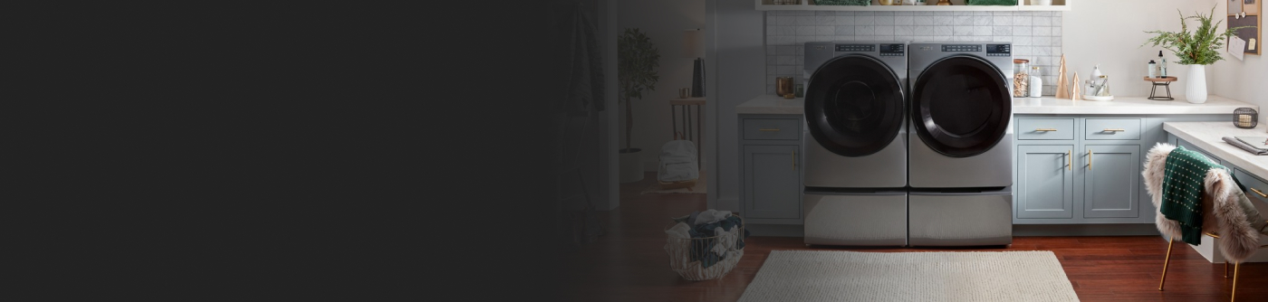 Whirlpool® Front Load Washer and Dryer pair on pedestals in a laundry room 