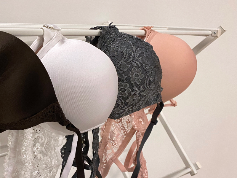 Four bras hanging on a drying rack