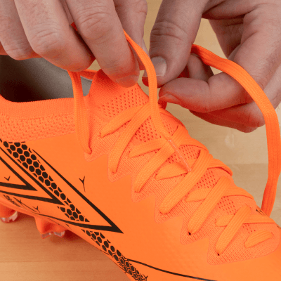 Person untying orange cleats