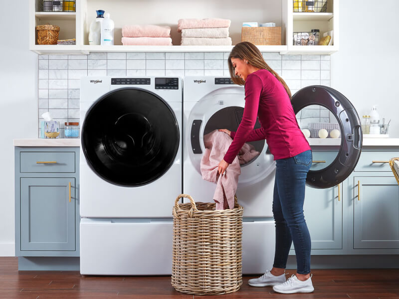 Person putting clothes in Whirlpool® washer Person putting clothes in Whirlpool® washer