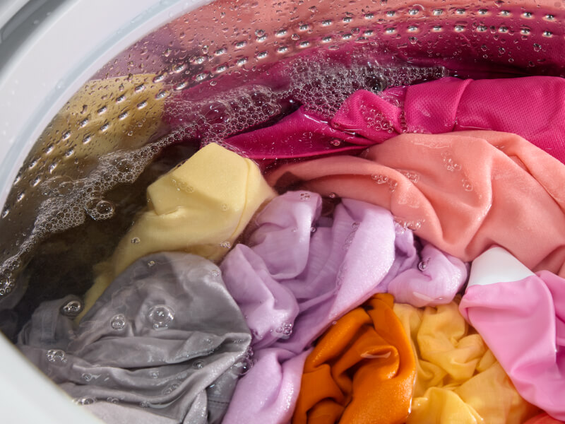 Brightly colored clothing in a washing machine Brightly colored clothing in a washing machine