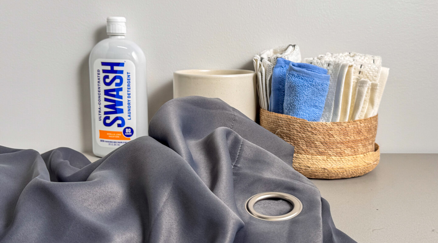 Grey curtains near a bottle of Swash® Laundry Detergent Grey curtains near a bottle of Swash® Laundry Detergent