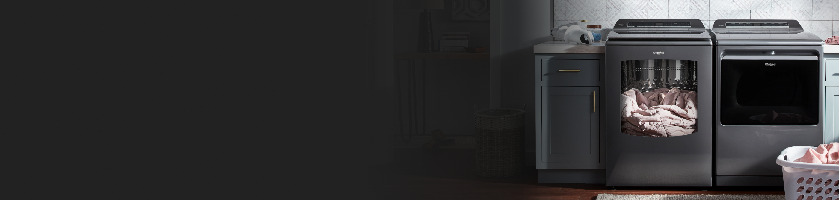 A blanket inside a Whirlpool® washer next to a Whirlpool® dryer in a modern laundry room.