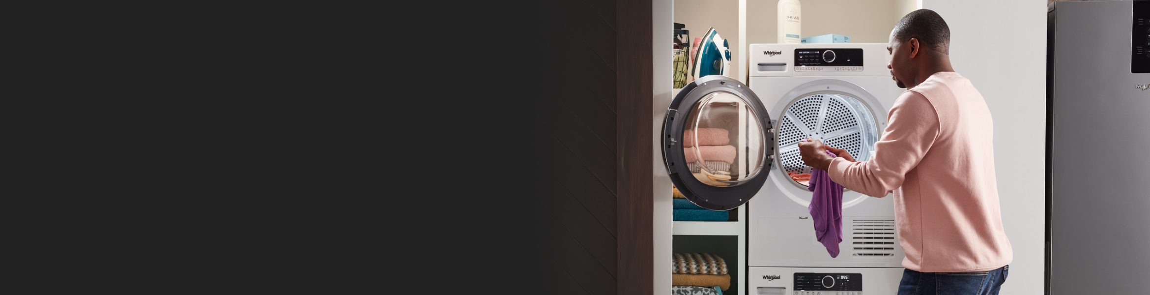 A man pulling a piece of clothing out of the dryer