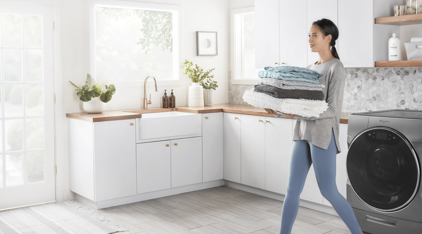 Person carrying towels in a laundry room Person carrying towels in a laundry room