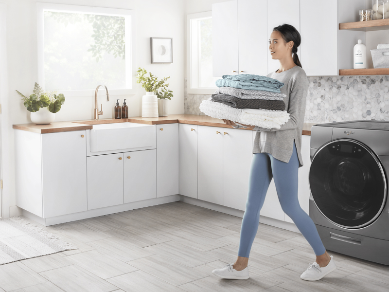 Person carrying towels in a laundry room Person carrying towels in a laundry room