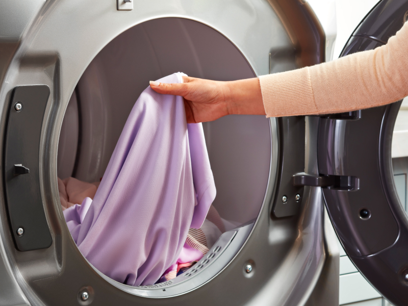 Person removing garment from the dryer Person removing garment from the dryer