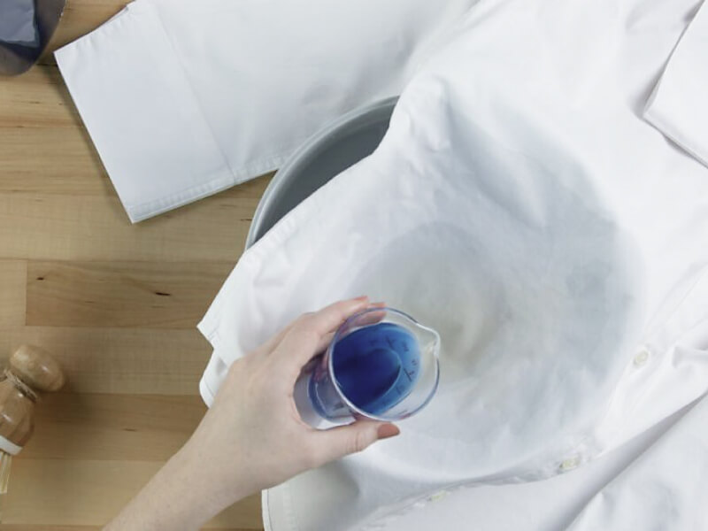 Person pretreating a stain Person pretreating a stain