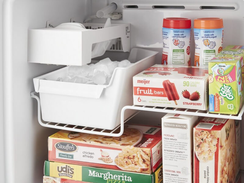 Close-up of full ice maker bin inside of freezer compartment