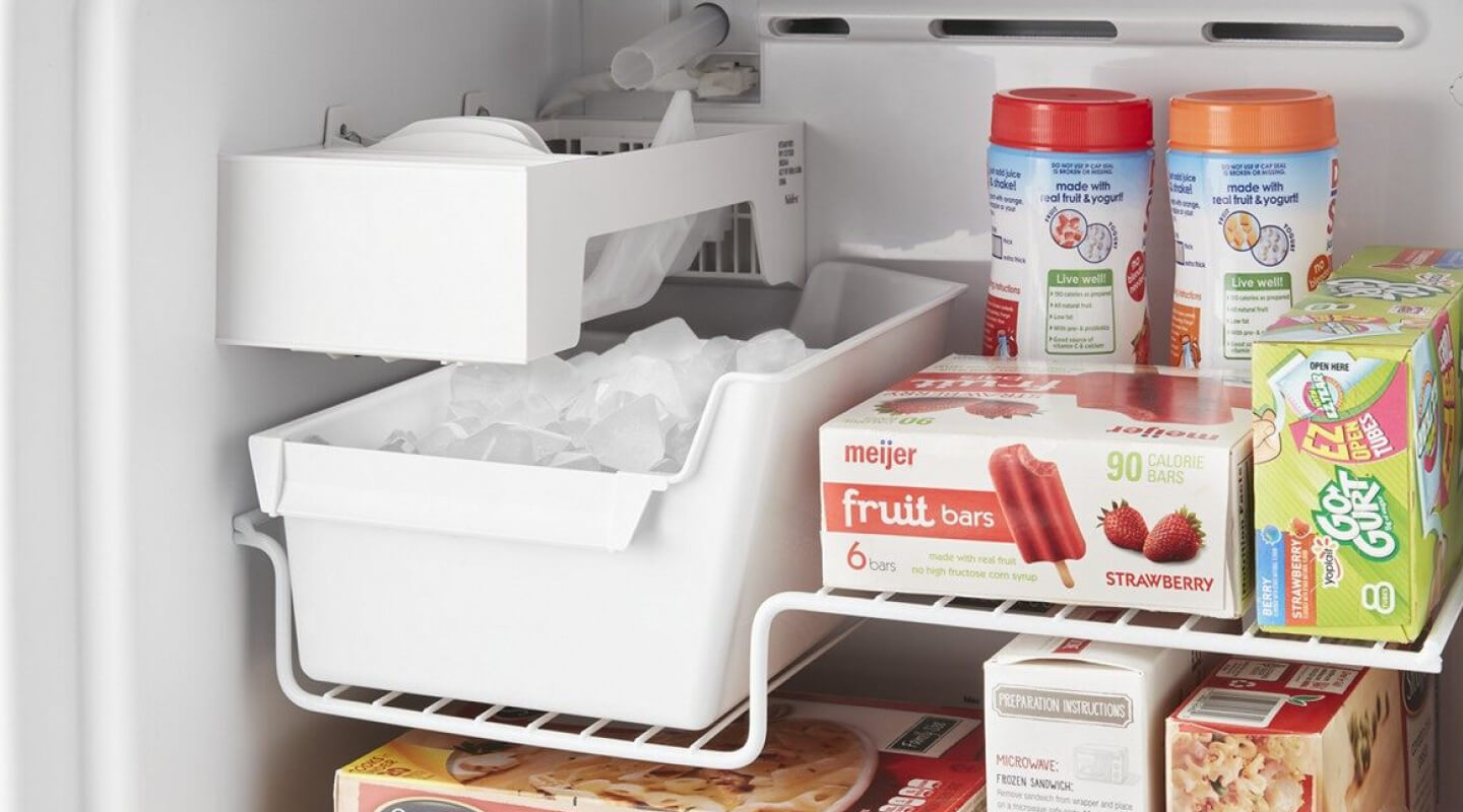 Close-up of full ice maker bin inside of freezer compartment