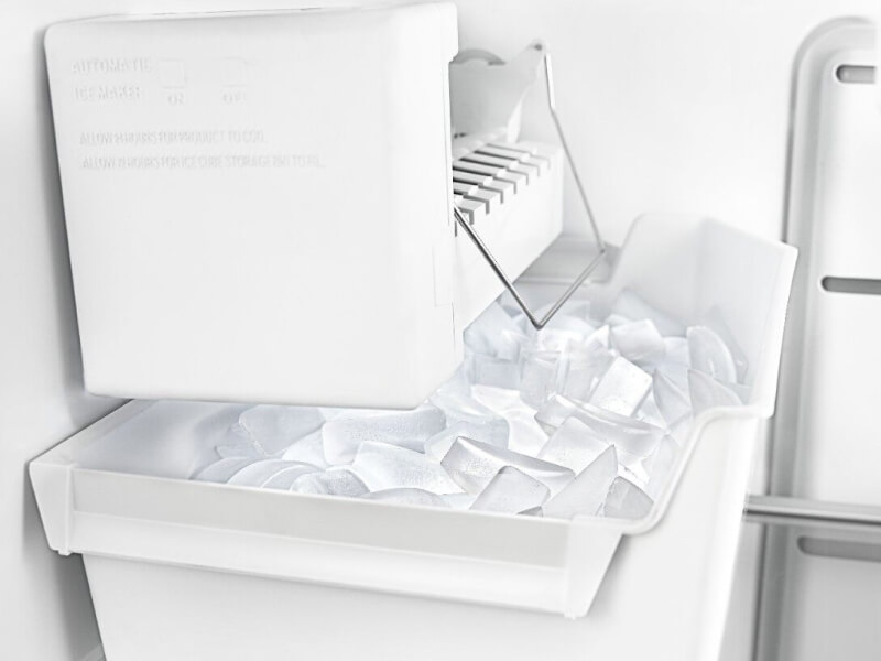 White ice maker inside freezer compartment with full ice bin
