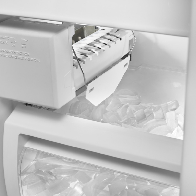 Close-up of ice maker dispenser arm above full bin of ice