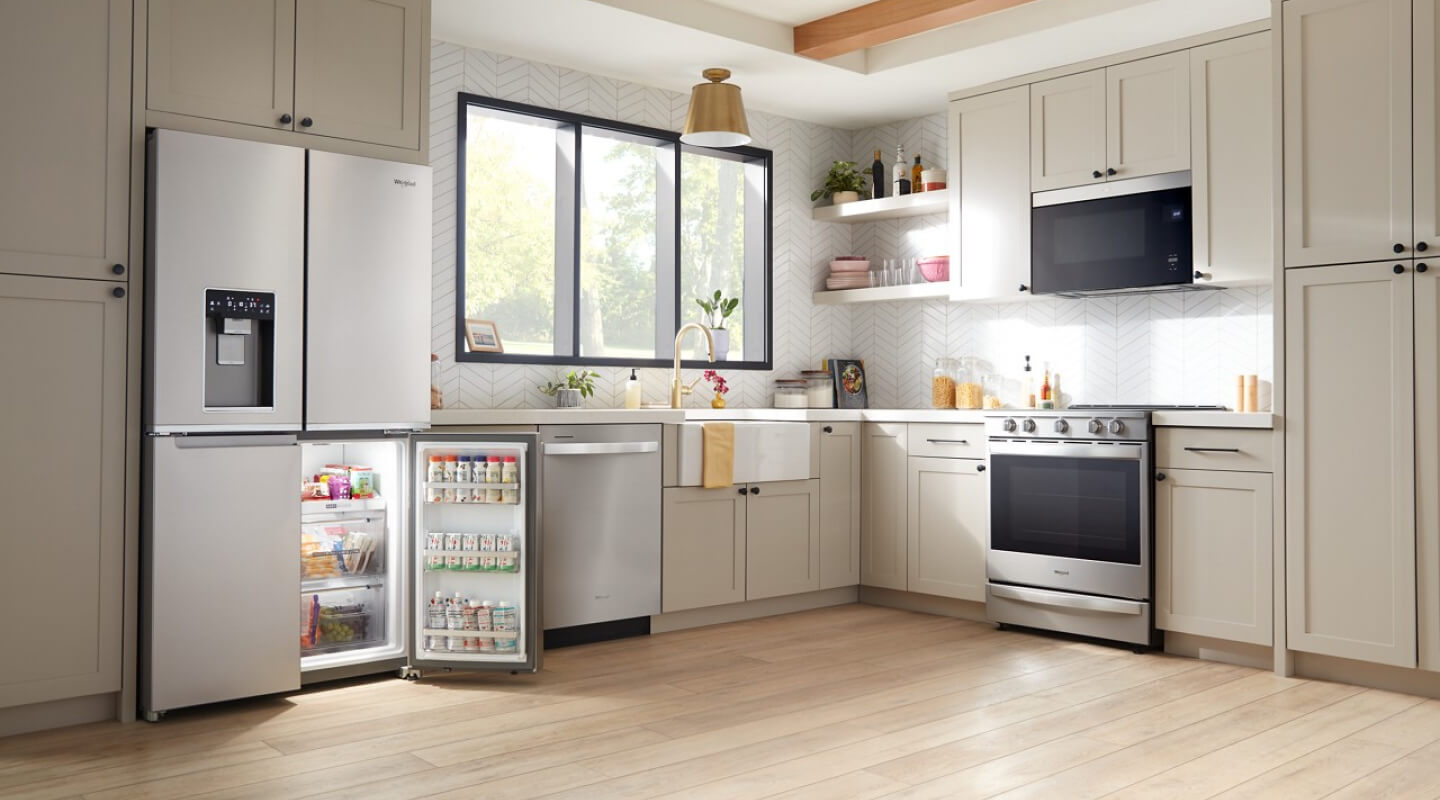 A light kitchen with a large window and stainless steel appliances