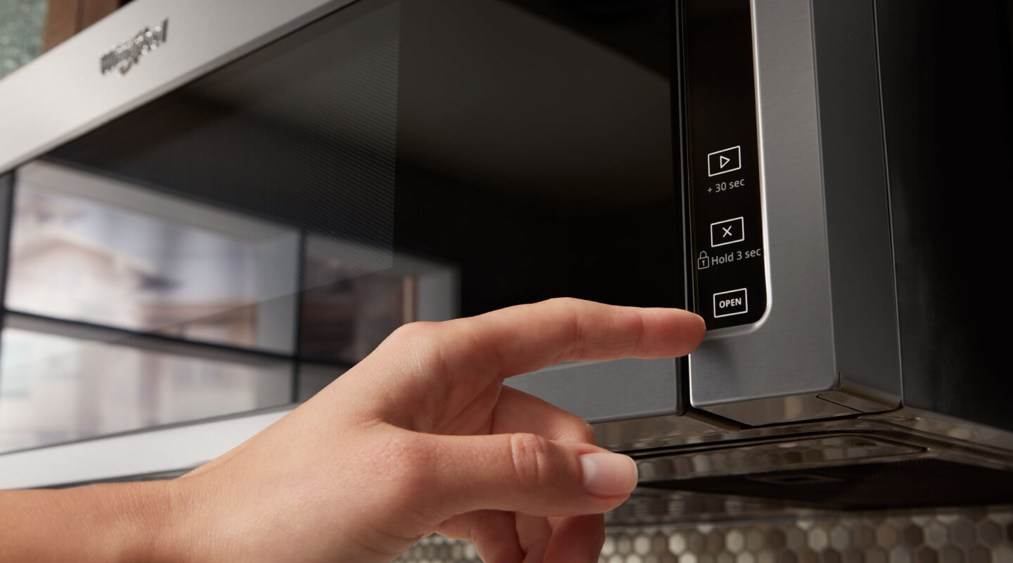 Person selecting a cook setting on a Whirlpool® microwave Person selecting a cook setting on a Whirlpool® microwave