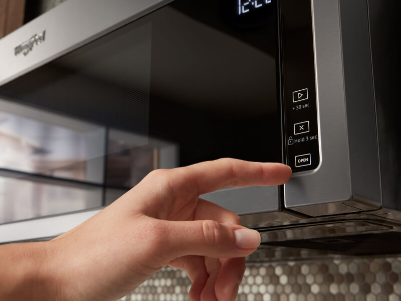 Person selecting a cook setting on a Whirlpool® microwave Person selecting a cook setting on a Whirlpool® microwave
