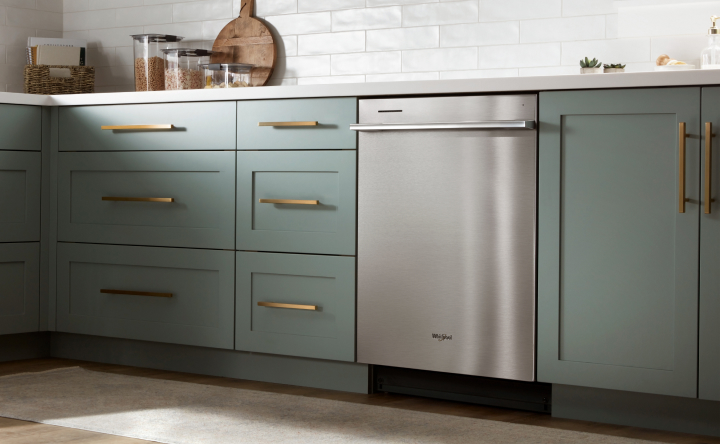 Stainless steel dishwasher in green kitchen 