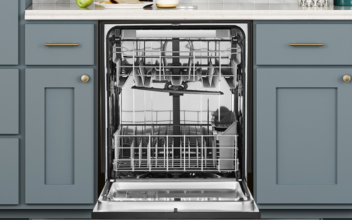 Open empty dishwasher among kitchen cabinets