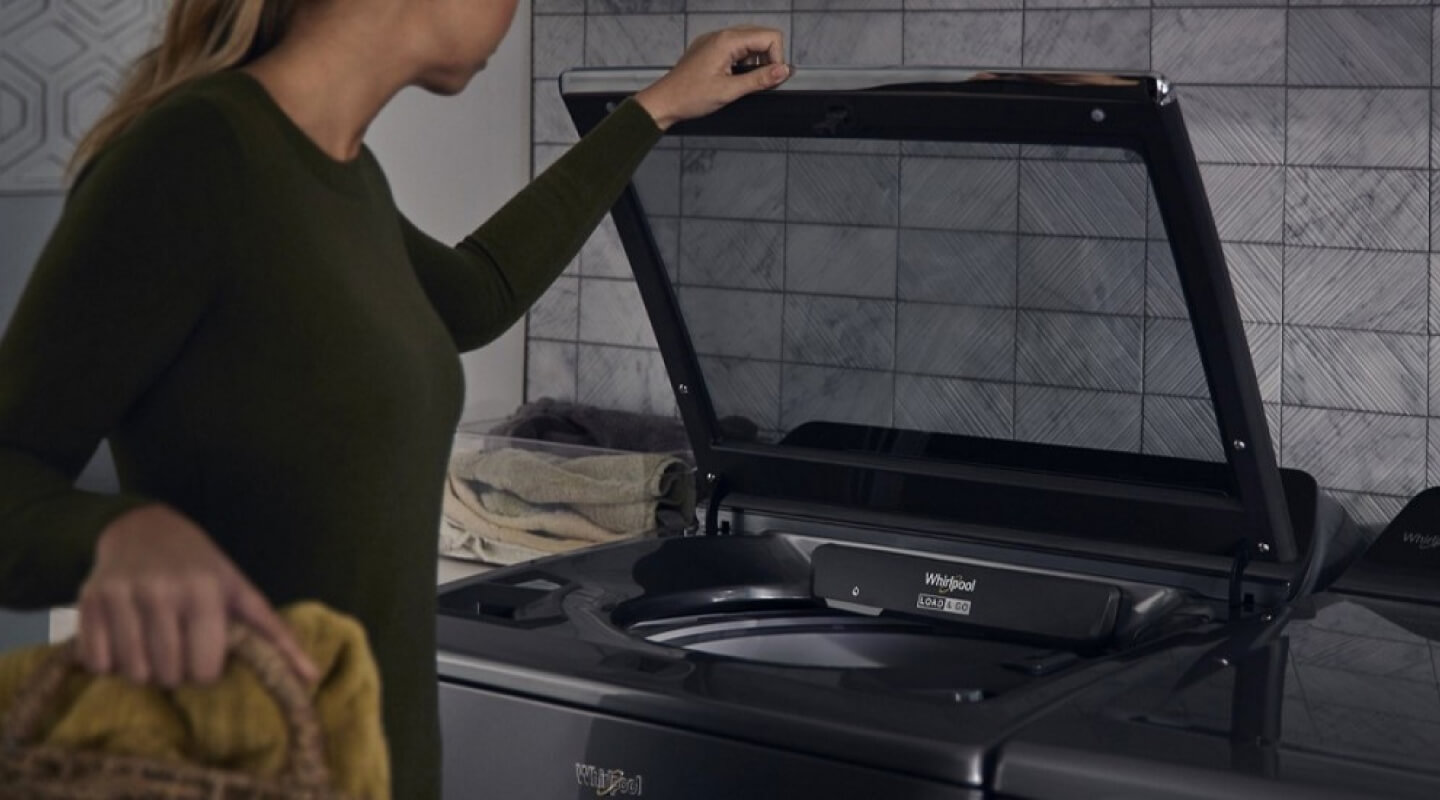 Person loading laundry into washer 