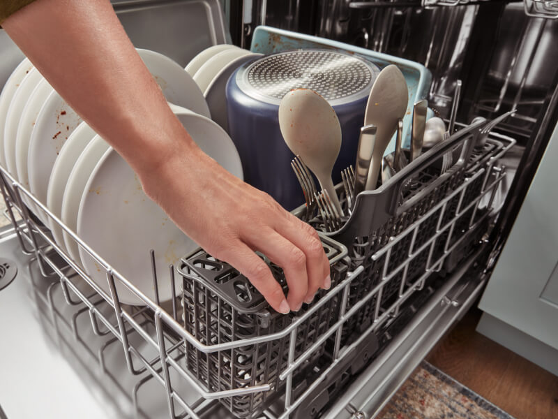 Person loading a dishwasher Person loading a dishwasher