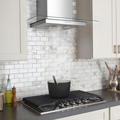 Vent hood over a gas cooktop heating a pot