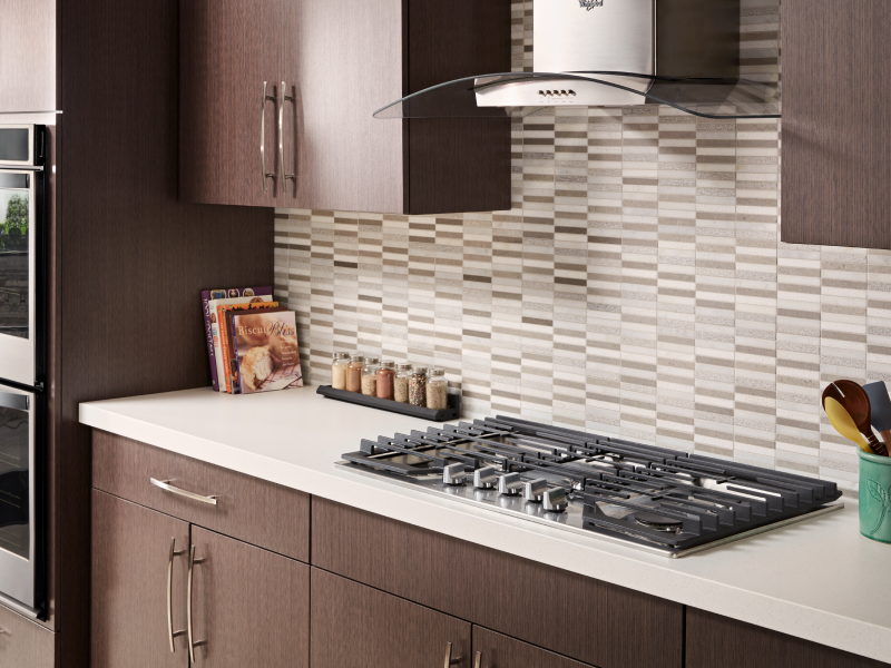 Gas cooktop installed into countertops with a vent hood above it Gas cooktop installed into countertops with a vent hood above it
