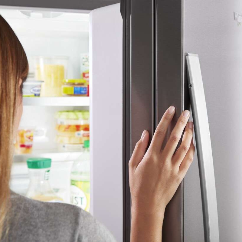 Close-up of a person’s hand on a fingerprint-resistant refrigerator door 