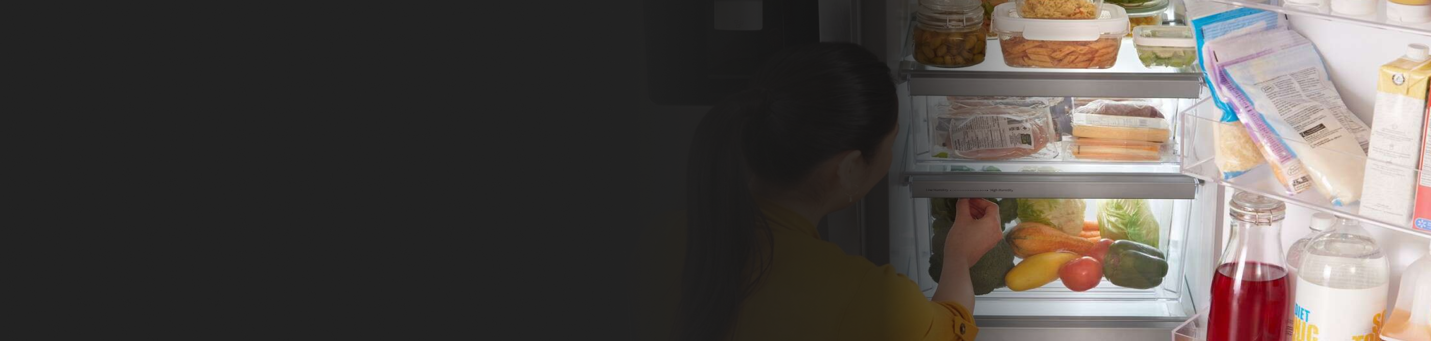 Person adjusting the humidity levels on a refrigerator crisper drawer