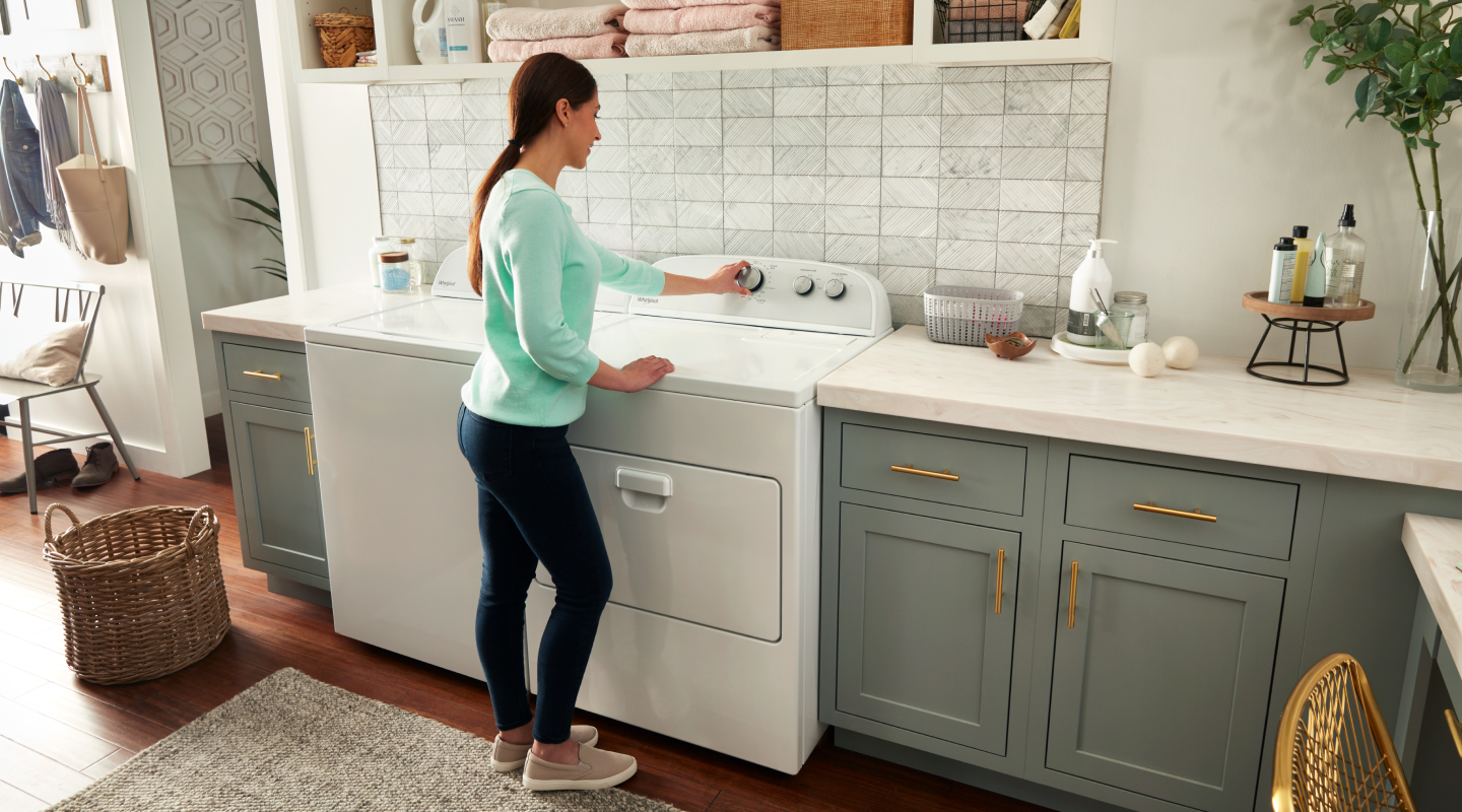 Woman selecting a cycle on a white Whirlpool® dryer Woman selecting a cycle on a white Whirlpool® dryer