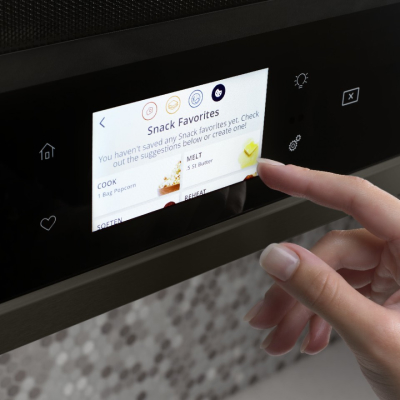 Person selecting settings on a Whirlpool® Smart Over-the-Range Microwave