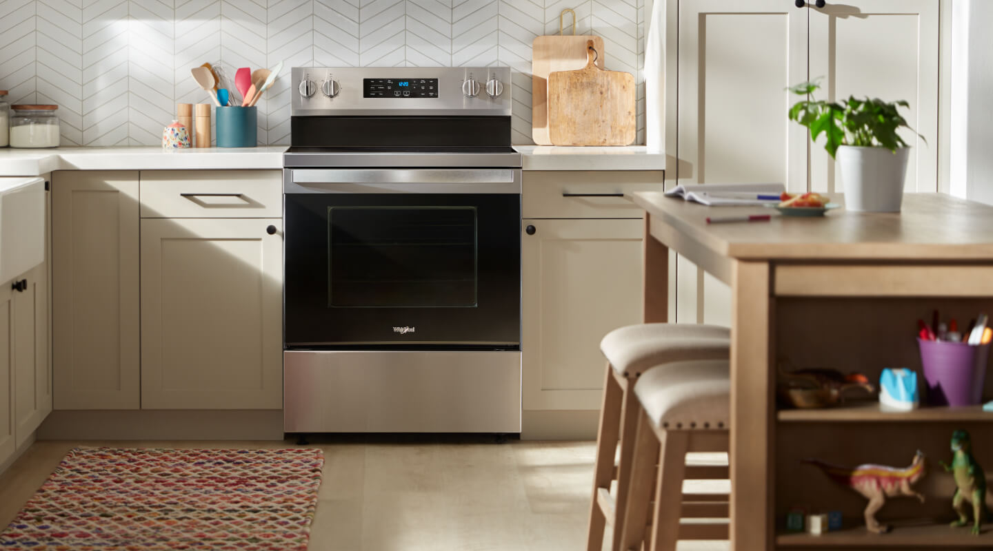 A kitchen with white counters, light cabinets and a Whirlpool® Range