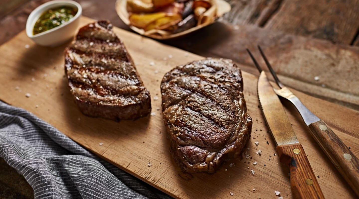 Two steaks on a cutting board