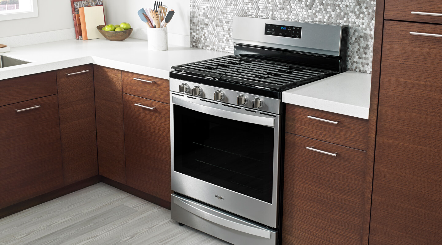 Freestanding gas range in a kitchen with wood cabinets