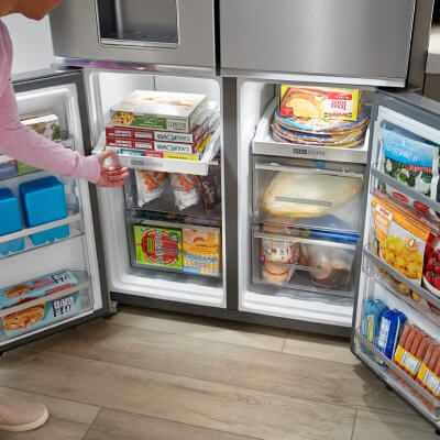 A four door refrigerator with opened bottom compartments