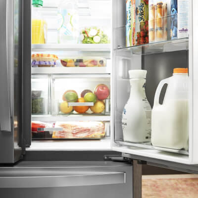 A Whirlpool® Refrigerator with door opened and a fully stocked interior