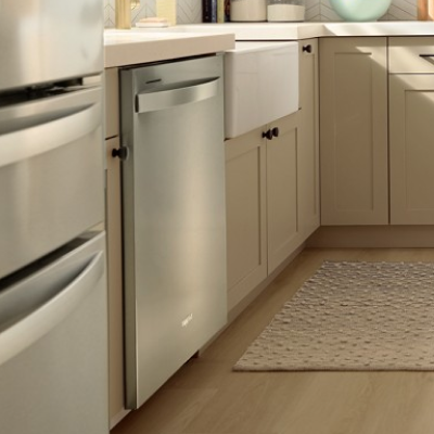A stainless steel Whirlpool® Dishwasher in a kitchen with light cabinets