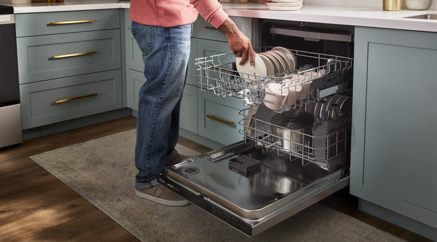 A person loading a dishwasher A person loading a dishwasher