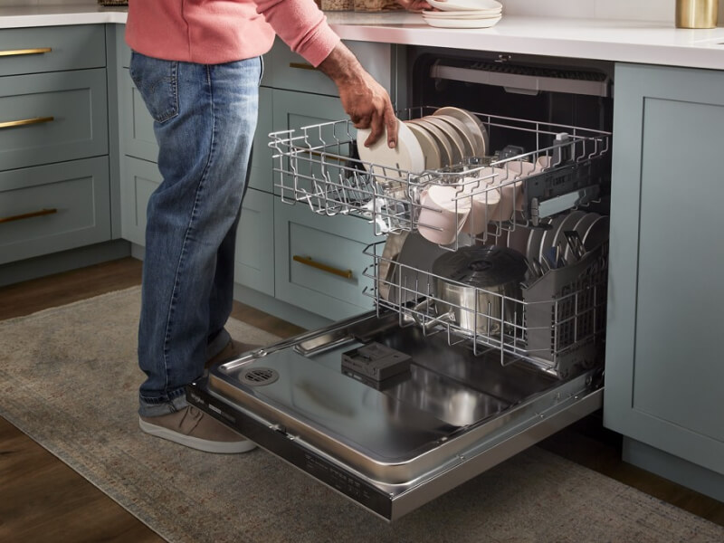 A person loading a dishwasher A person loading a dishwasher