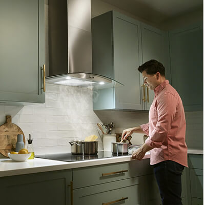Person stirring a pot of food on an electric cooktop