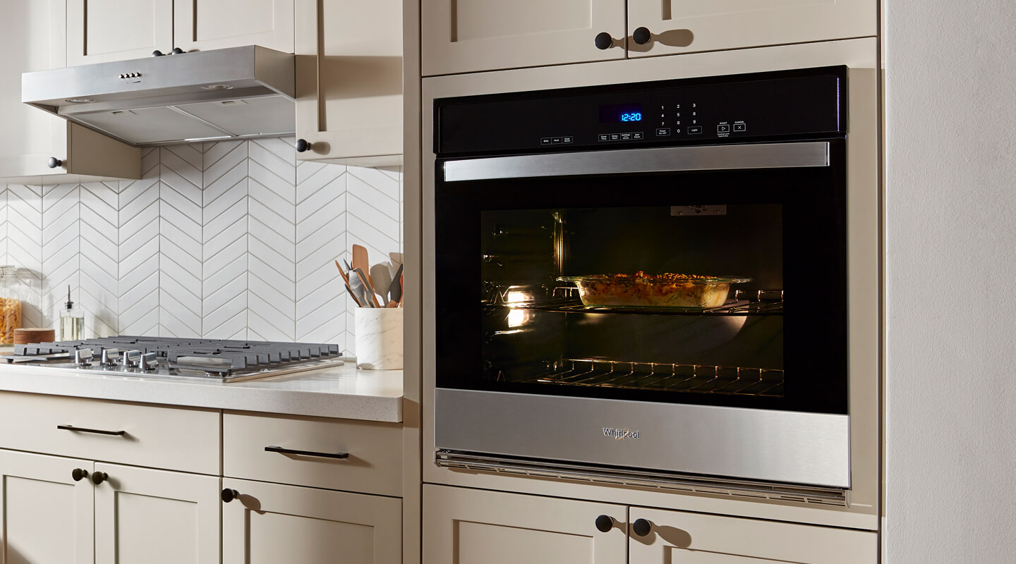 A stainless steel single wall oven in a kitchen with light beige cabinetry