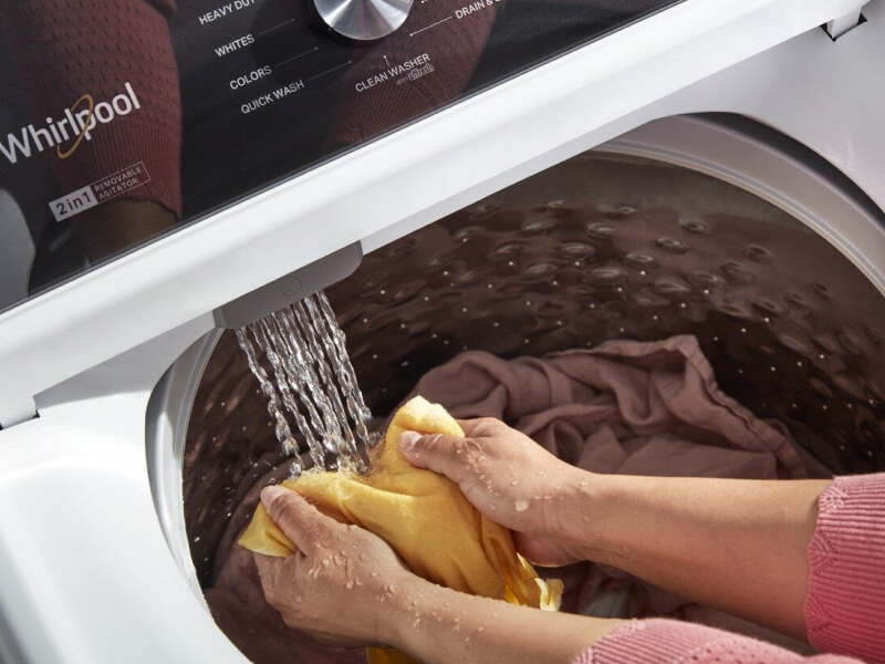 A person soaking clothes in a Whirlpool® washer A person soaking clothes in a Whirlpool® washer
