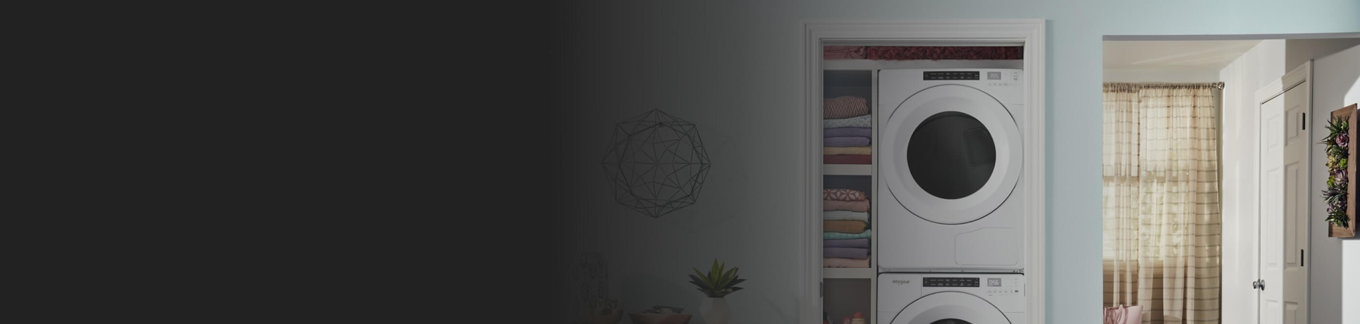 White Whirlpool® Stacked Washer and Dryer in a laundry closet