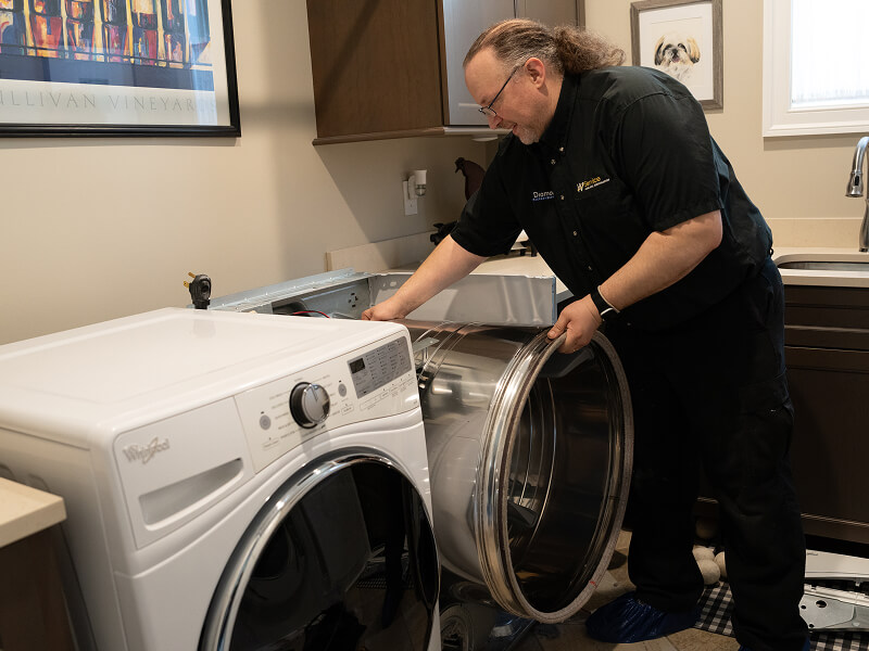 A technician working on a dryer A technician working on a dryer